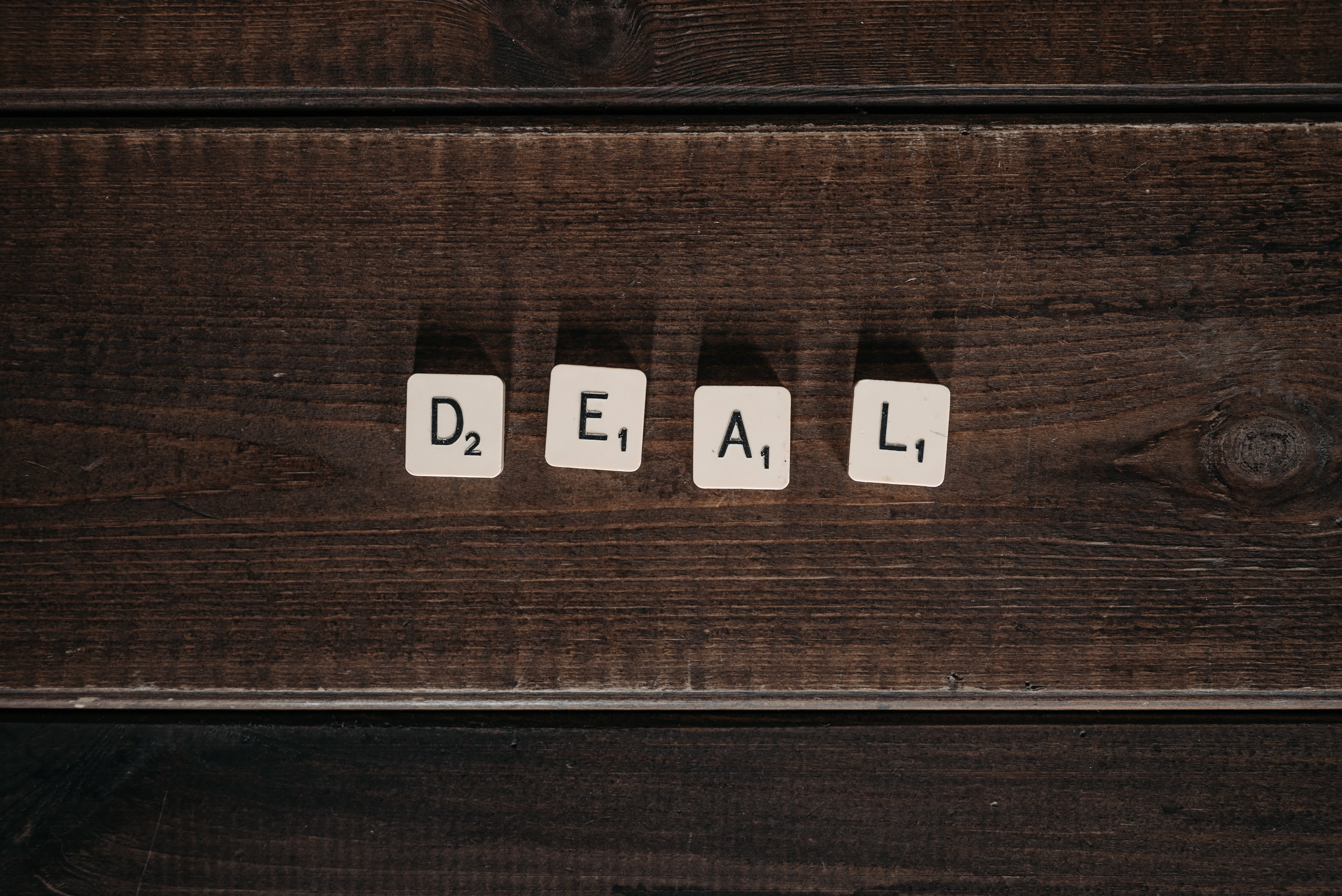 Scrabble tiles spelling the word 'deal.'