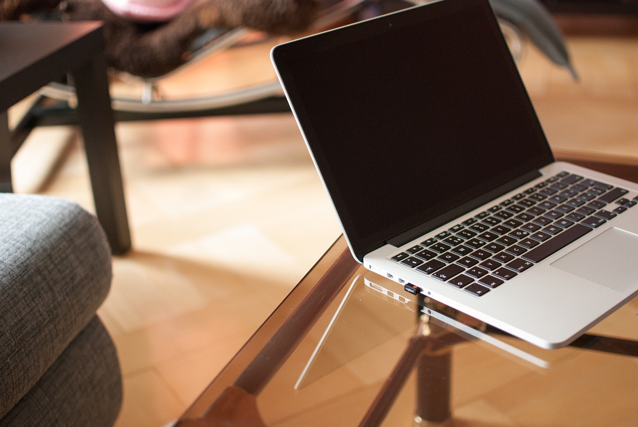 A laptop sits on a coffee table.