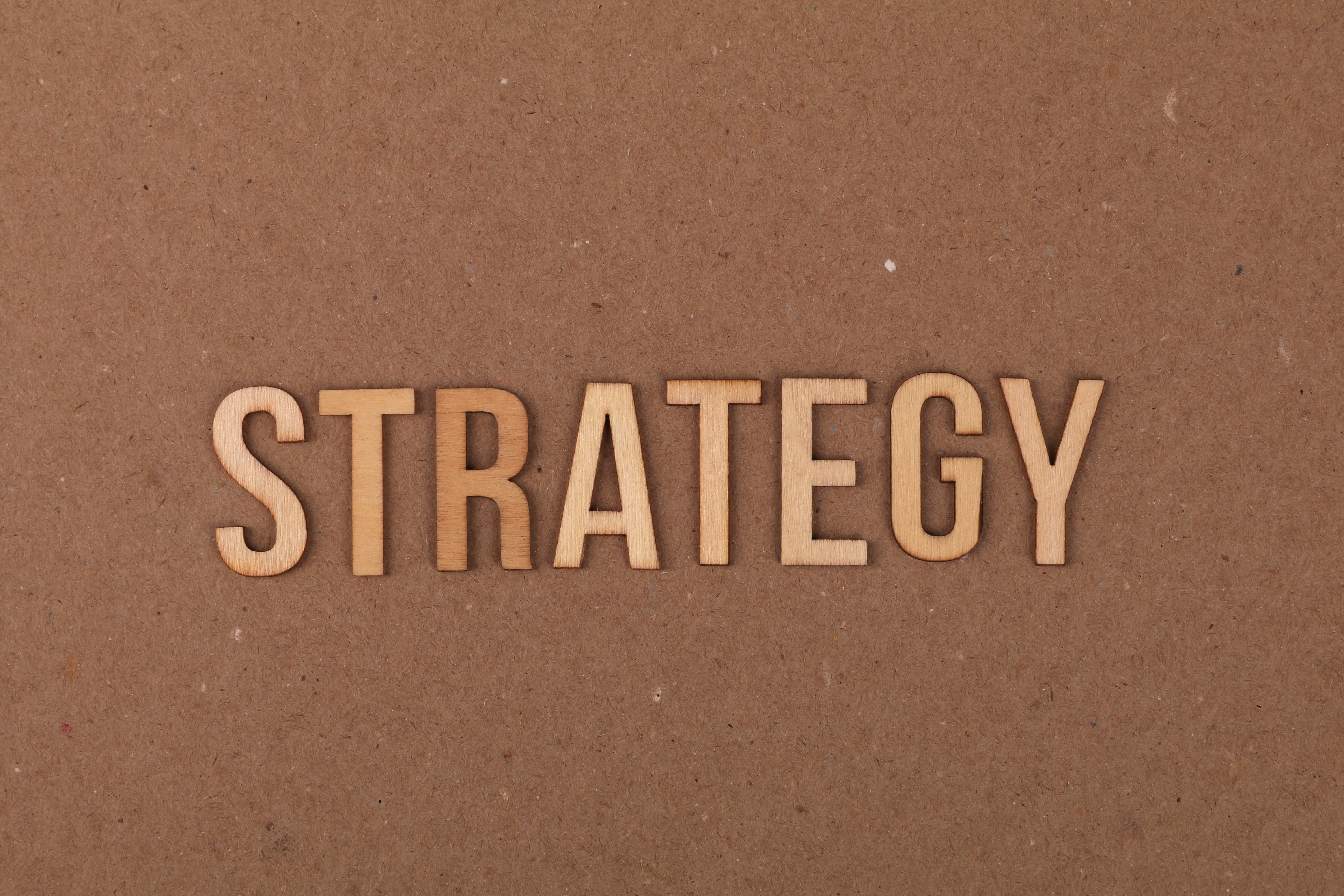 The word "strategy" with a cardboard background.