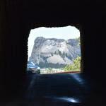 Mount Rushmore framed through a tunnel, showcasing iconic presidential sculptures in South Dakota.