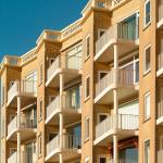 Contemporary apartment building featuring multiple balconies, ideal for urban living environments.