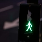a green pedestrian walk sign on a pole