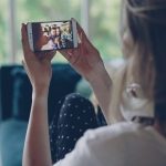 Woman watching video on smartphone indoors