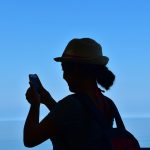 a woman with a hat is looking at her cell phone