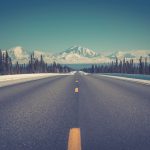asphalt road between trees under blue clear sky during daytime