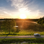 Aerial view of a countryside road with car and person at sunset in Mantinge, Netherlands.