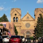 cars parked in front of brown concrete building during daytime