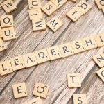 scrabble tiles spelling out the word leadership on a wooden surface