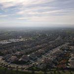 Bird's eye view of a suburban residential area in Dublin, CA with a clear sky and distant hills.