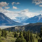 snow capped mountains with valley and forest
