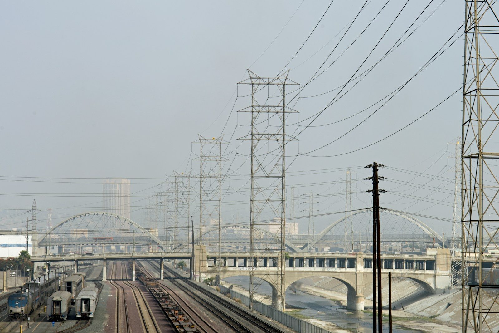 A train traveling down train tracks next to a bridge