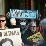 Protesters hold signs at a demonstration