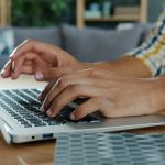 Person typing on a laptop computer at a desk