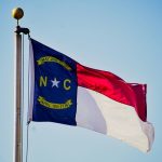 North carolina flag waving against a blue sky