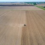an aerial view of a farm with a tractor in the middle of the field